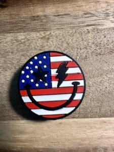 A round pin featuring an eagle on a U.S. flag with patriotic colors.