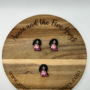 Wooden board labeled "African American Barbara" with three pins depicting a character in a pink outfit and flowing hair, all arranged in a neat pattern.