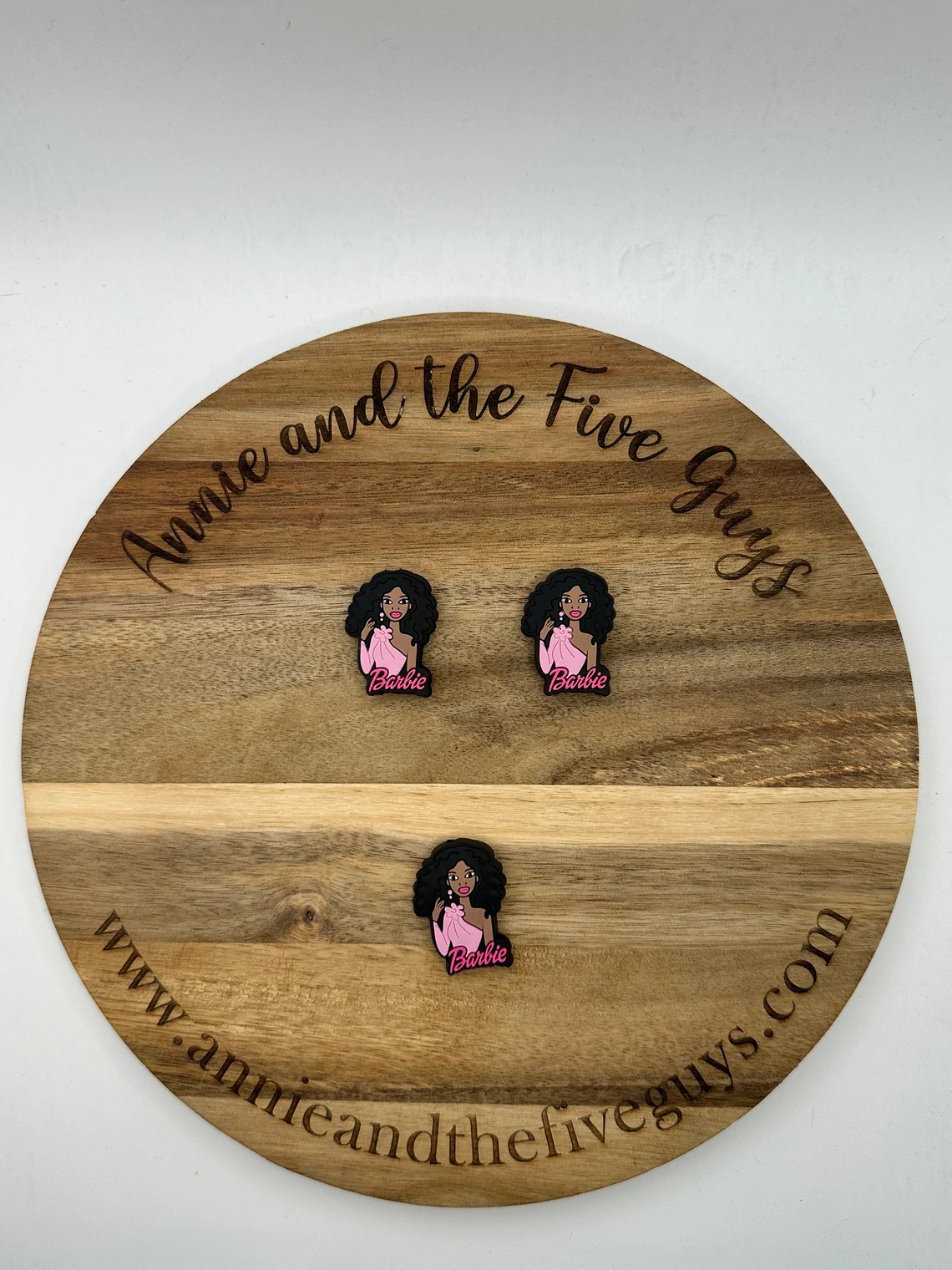 Wooden board labeled "African American Barbara" with three pins depicting a character in a pink outfit and flowing hair, all arranged in a neat pattern.