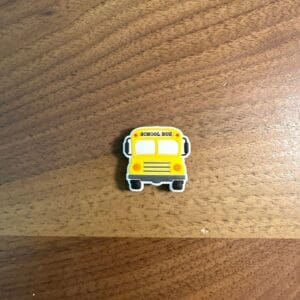 Small yellow school bus eraser on a wooden surface.