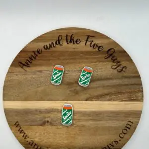 A round wooden plaque with the text "Annie and the Five Guys" and "www.annieandthefiveguys.com" features a White soda silicone focal bead.