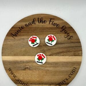 A wooden plaque with “Annie and the Five Guys” is engraved around its edge, displaying three round white pins, each with red and green designs and text reading "De La Rosa Mazapan.