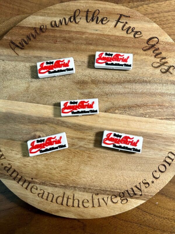 Five rectangular pins with red and black text reading "Lady Luscious Lips" displayed on a circular wooden board with the text "Annie and the Five Guys" around the edge.