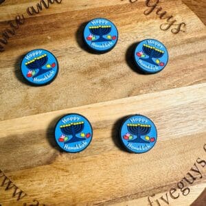 Round wooden board with five blue Hanukkah-themed magnets displaying a menorah and the text "Happy Hanukkah.