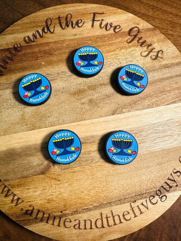 Round wooden board with five blue Hanukkah-themed magnets displaying a menorah and the text "Happy Hanukkah.