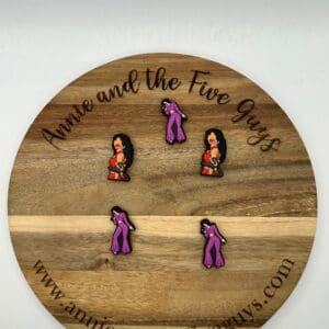 Five Selena silicone focal beads featuring a woman in red and purple attire are displayed on a round wooden board with the text "Annie and the Five Guys" and a website URL.