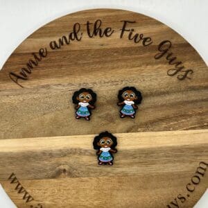 Three small figurines of a child with curly hair and a blue dress are displayed on a round wooden plaque that reads "Annie and the Five Guys" around the edge.