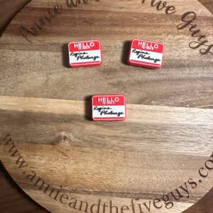 Three hello buttons kept on a wooden plate