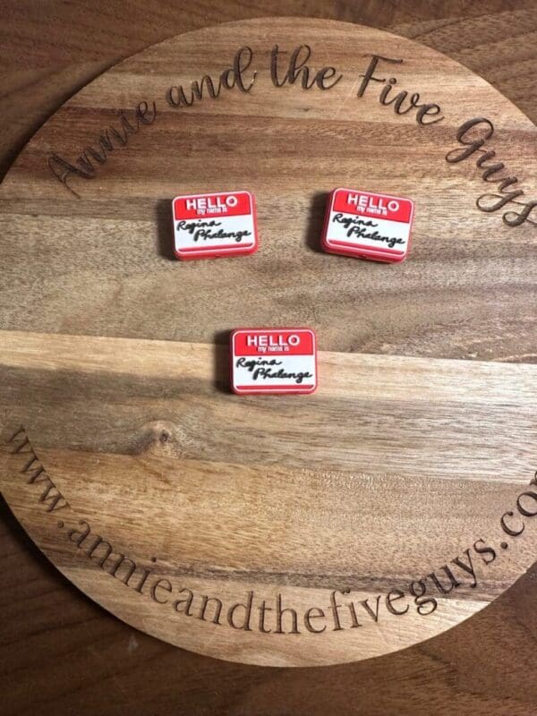 Three hello buttons kept on a wooden plate