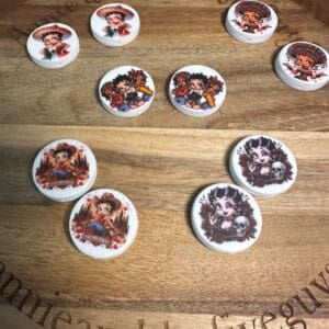 Betty Boop silicone focal beads, multicultural, featuring various cartoon character designs are arranged on a wooden surface engraved with text.