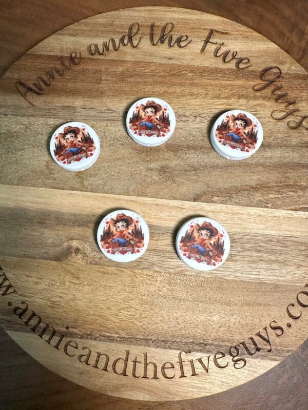 Five round Betty Boop silicone focal beads, multicultural, featuring a character illustration are displayed on a circular wooden board with engraved text.