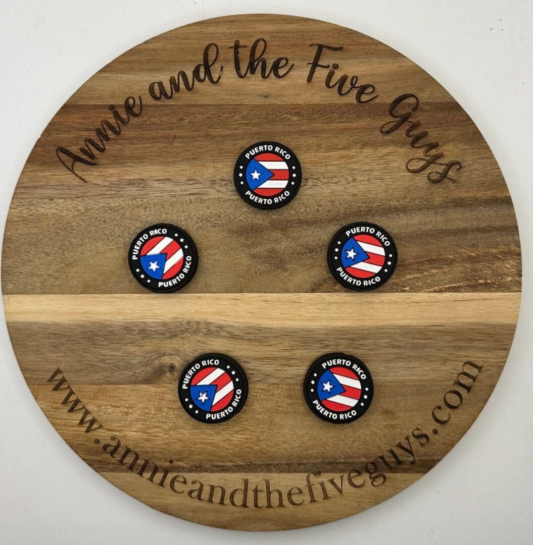 A wooden board with the text "Annie and the Five Guys" holds four round buttons labeled "Puerto Rico," each featuring the Puerto Rican flag. The website "www.annieandthefiveguys.com" is at the bottom.