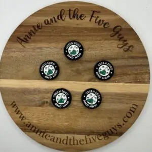 A wooden board with "Annie and the Five Guys" inscribed around its edge displays four circular green badges reading, "Green Eggs and Ham" with an illustration of green eggs and ham in the center.