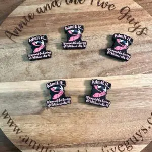 A wooden board with the text "Annie and the Five Guys" displays six Flamingo, funny silicone focal beads that read "Admit it. You would be boring without me." with a pink design. The website amyandthefiveguys.com is also visible.