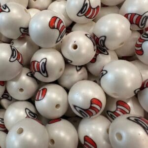 A pile of white spherical objects each featuring a red and white striped hat graphic, resembling the iconic "Cat in the Hat" design.