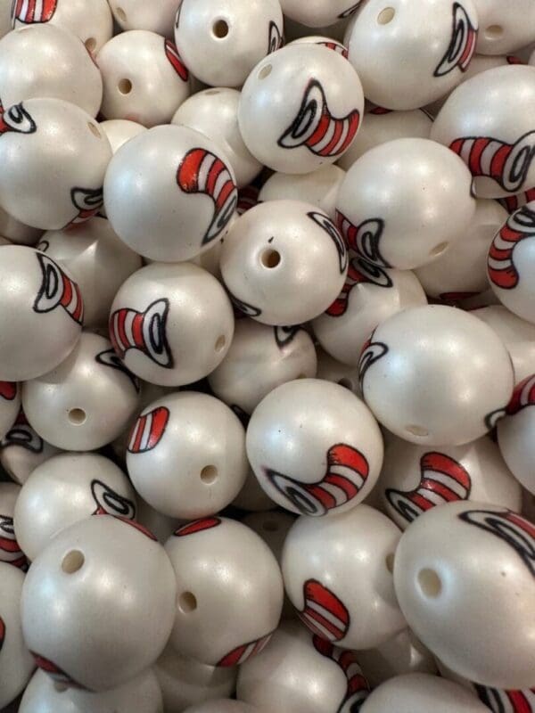 A pile of white spherical objects each featuring a red and white striped hat graphic, resembling the iconic "Cat in the Hat" design.