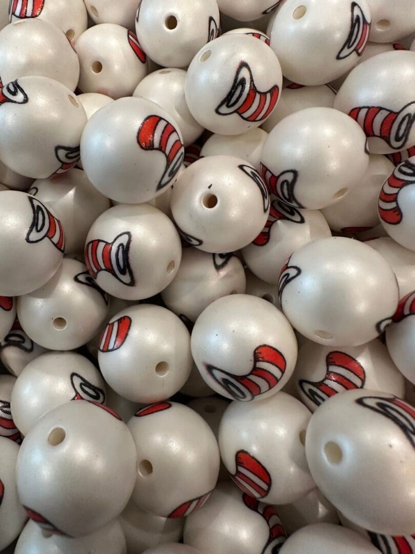 A pile of white spherical objects each featuring a red and white striped hat graphic, resembling the iconic "Cat in the Hat" design.