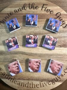 A wooden surface displays nine square items featuring various images of a political figure. The website "annieandthefiveguys.com" is printed on the wood.