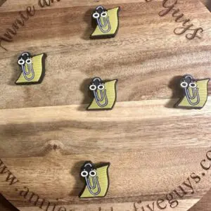 A round wooden board featuring five Paperclip and Paper silicone focal beads, each depicting a yellow cartoon character with glasses, and engraved with the text "annieandthefiveguys.com.