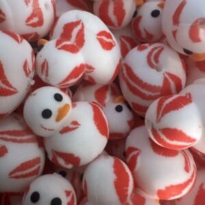 A pile of rubber ducks, white with orange beaks and black eyes, covered in red lip print patterns.