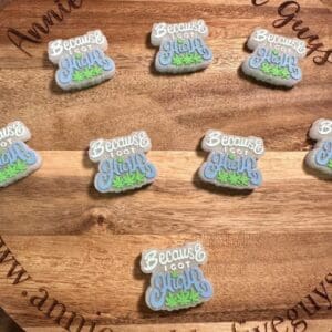 A silicone focal bead displaying several cookies with icing text reading "Because I got high" and decorative grass-like icing. The bead features an inscription saying "Annie and the Five Guys.