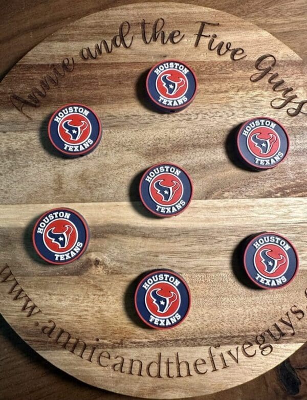 Round wooden board featuring seven Houston Texans Football silicone focal beads arranged in a circular pattern. The board is inscribed with "Annie and the Five Guys" and "www.annieandthefiveguys.com.