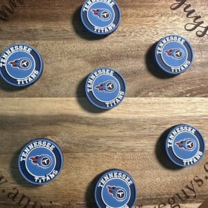 Wooden circular tray with the text "Annie and the Five Guys" displaying six Tennessee Football silicone focal beads arranged in rows.