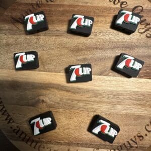 Seven black drink coasters with the 7UP logo are arranged on a wooden surface displaying the text "www.annmeandthefiveguys.com" around the edge.