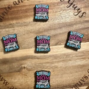 Five identical decorative magnets on a wooden board, each with the phrase "Tough enough to be a Mom, crazy enough to love it.