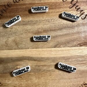 Six small pins on a wooden board, each with the text "ALLERGIC TO FRIDAYS.