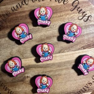 Wooden board with eight Chucky-themed pins arranged in a pattern. Each pin features a cartoon figure with "Chucky" written below.