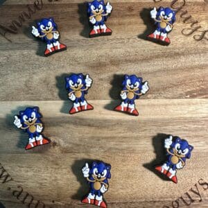 Pins featuring a cartoon hedgehog in red shoes are arranged on a round wooden board.