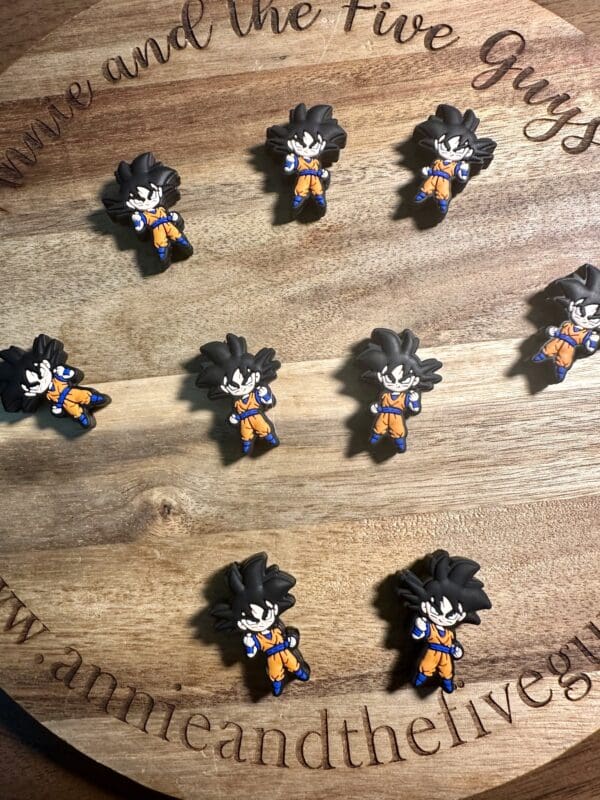 Nine mini figurines of an animated character on a wooden surface.