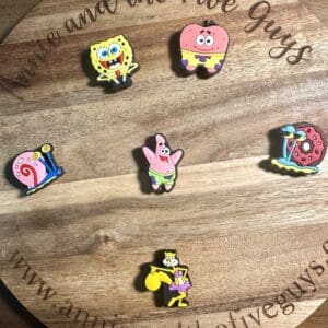 Round wooden board with six cartoon character pins from a popular animated series.