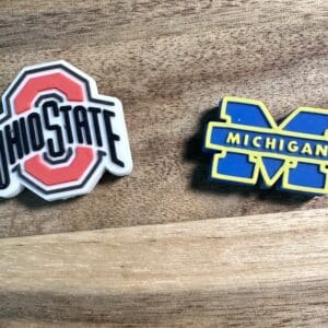 Ohio State logo and Michigan logo on a wooden surface.