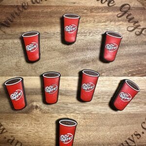 Seven Dr Pepper magnets arranged on a wooden surface with text "Annie and the Five Guys" visible.