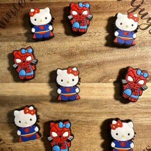 Nine custom cookies on a wooden board, featuring Hello Kitty and Spider-Man designs.