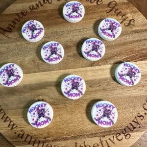 Wooden platter with ten round "Hockey Mom" decorated cookies, featuring a purple hockey player silhouette.