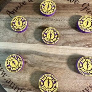 Round wooden board with six purple and yellow Wonka Factory logo cookies. Engraved text reads "Annie and the Five Guys.